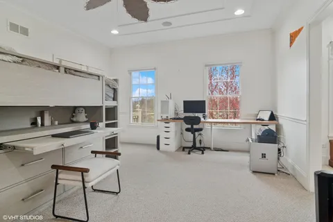 a view of a big house with a big yard and large trees