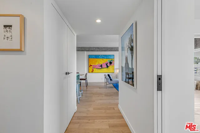 a view of a hallway with wooden floor and furniture