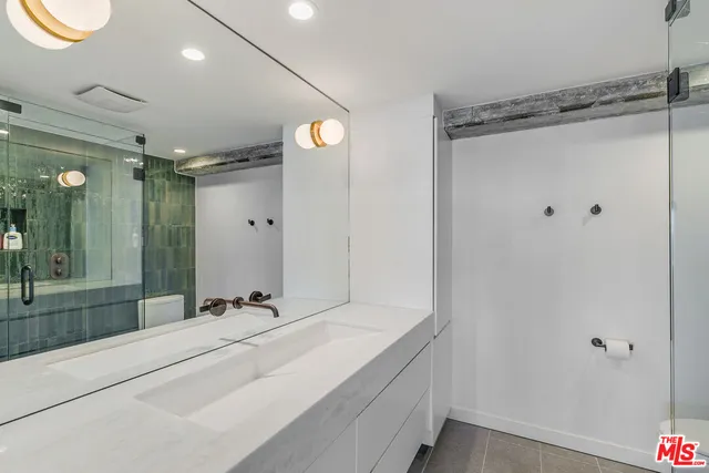 a bathroom with a shower sink and mirror