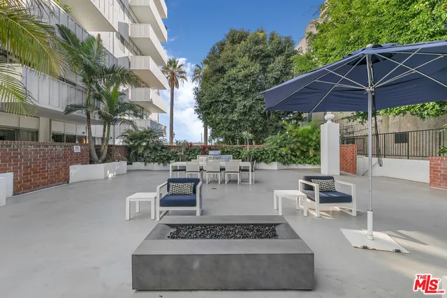 a view of a patio with couches and table under an umbrella