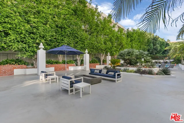a view of a patio with a table and chairs under an umbrella