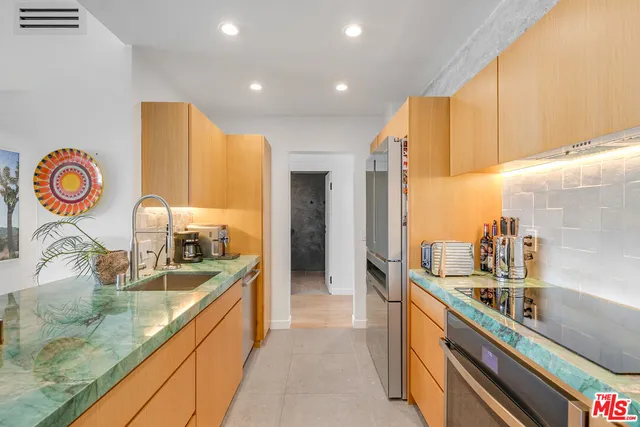 a large kitchen with kitchen island granite countertop a sink and a large window