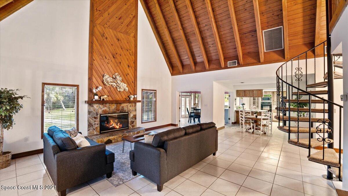 4455 Lake Washington Road Melbourne, FL 32934 - Photo 14 of 53 a living room with furniture a fireplace and large windows