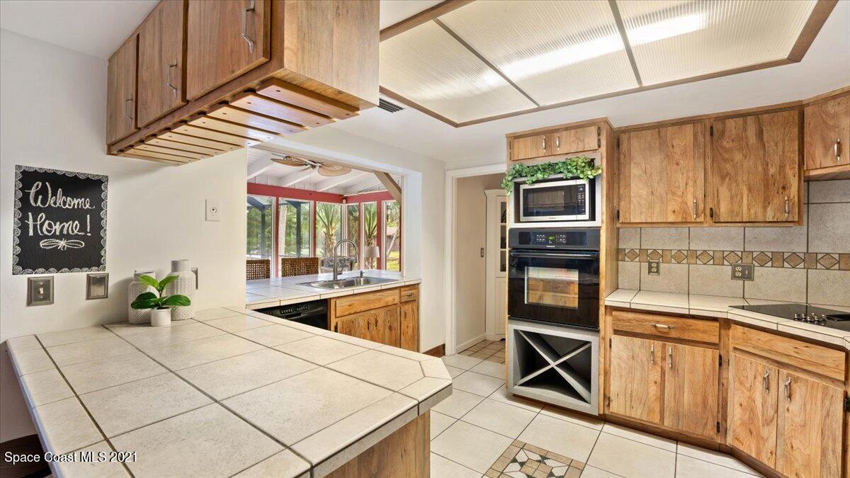 4455 Lake Washington Road Melbourne, FL 32934 - Photo 18 of 53 a kitchen with stainless steel appliances kitchen island granite countertop a refrigerator and a sink
