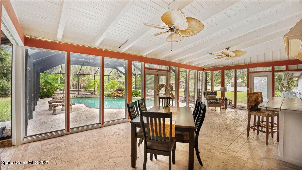 4455 Lake Washington Road Melbourne, FL 32934 - Photo 24 of 53 a dining room with furniture water view and a floor to ceiling window