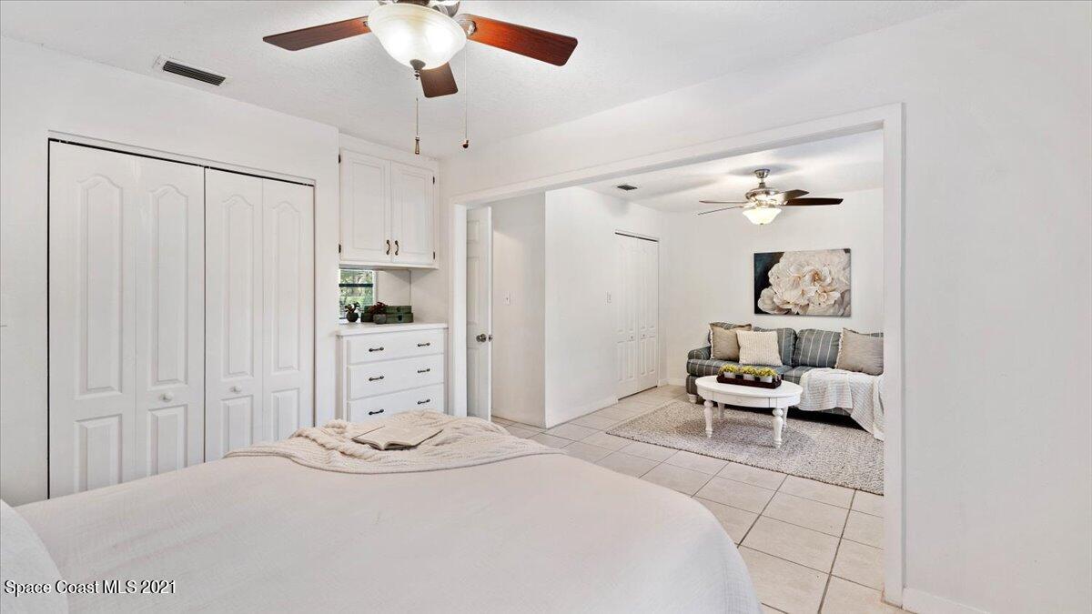 4455 Lake Washington Road Melbourne, FL 32934 - Photo 27 of 53 a bedroom with a bed and a chandelier