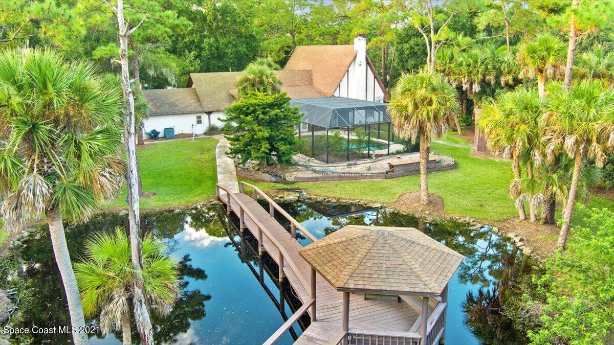 4455 Lake Washington Road Melbourne, FL 32934 - Photo 38 of 53 a view of a patio with table and chairs potted plants and large tree