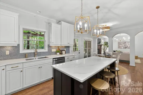a large kitchen with sink a window and dining table