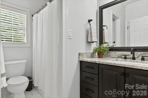 a bathroom with a granite countertop sink toilet and mirror