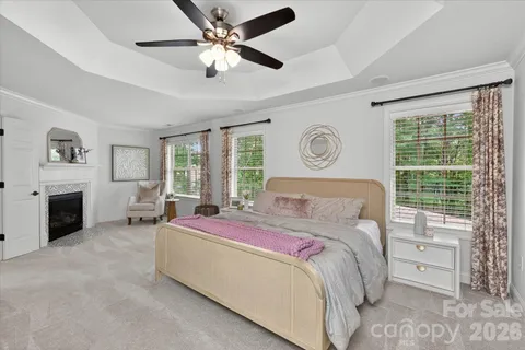 a bedroom with a bed flat screen tv and a fireplace