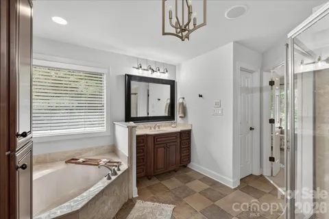 a bathroom with a tub a sink and a large mirror