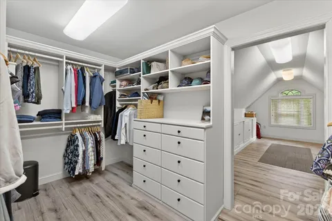 a view of walk in closet with clothes and shoes