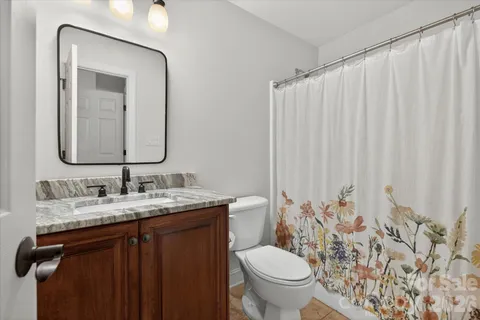 a bathroom with a granite countertop sink and a mirror with toilet