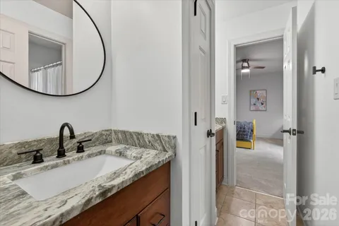 a bathroom with a granite countertop sink and a mirror