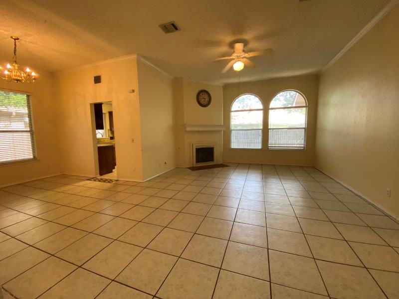 1903 Balsam Way Round Rock, TX 78665 - Photo 2 of 21 A spacious living area with arched windows and a cozy fireplace, perfect for gatherings.