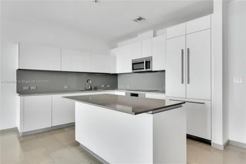 a kitchen with stainless steel appliances granite countertop a sink and a refrigerator