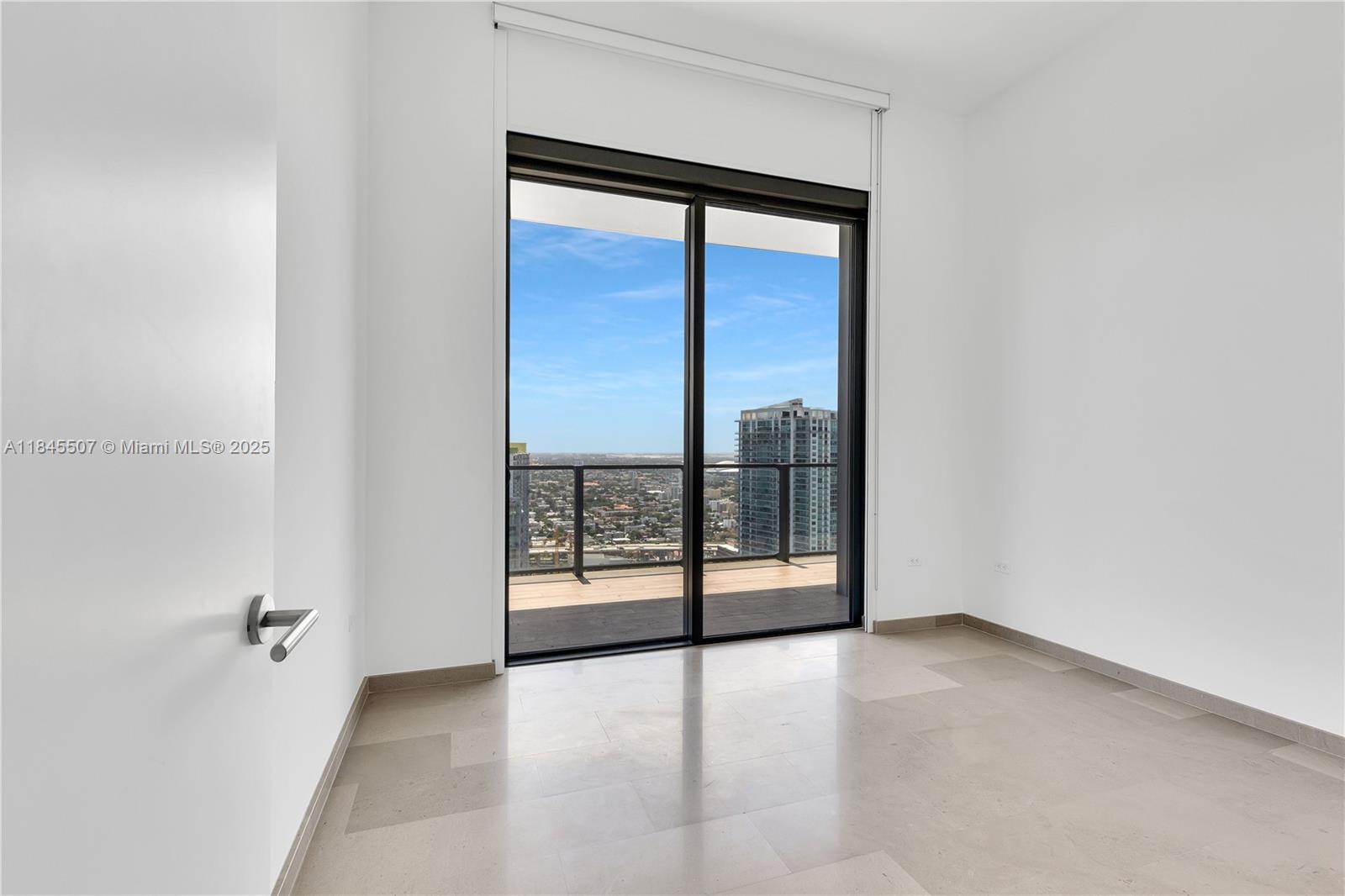 68 Southeast 6th Street, Unit 4110 Miami, FL 33131 - Photo 8 of 23 an empty room with sliding glass door and shower