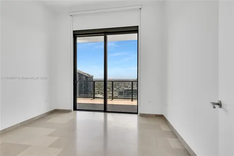 an empty room with sliding glass door and shower