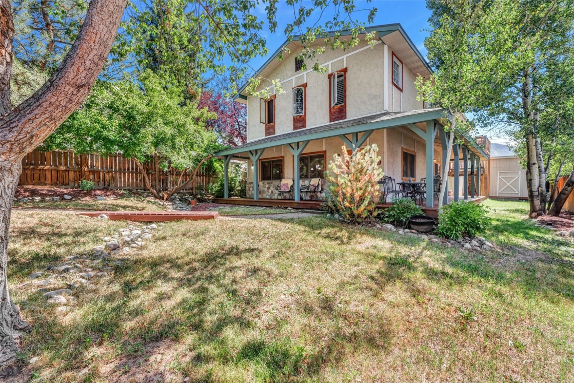 424 3rd Street Steamboat Springs, CO 80487 - Photo 2 of 48 a view of a white house with large trees and wooden fence