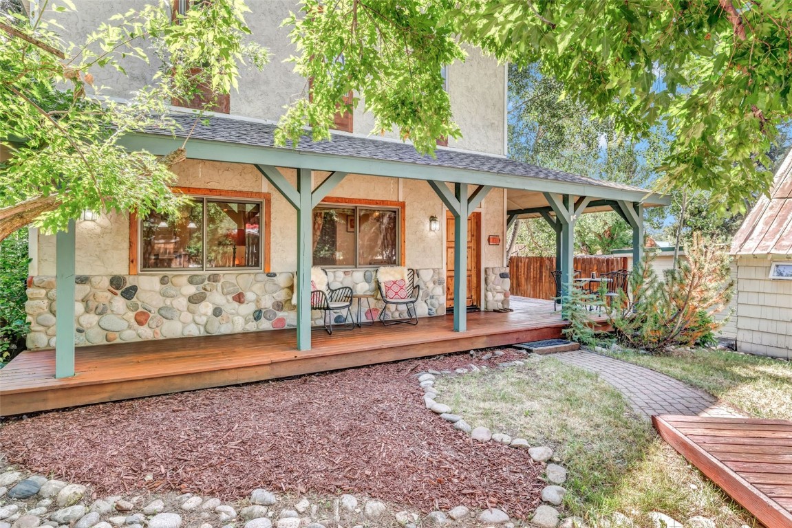 424 3rd Street Steamboat Springs, CO 80487 - Photo 34 of 48 a view of a patio with table and chairs under an umbrella with large trees