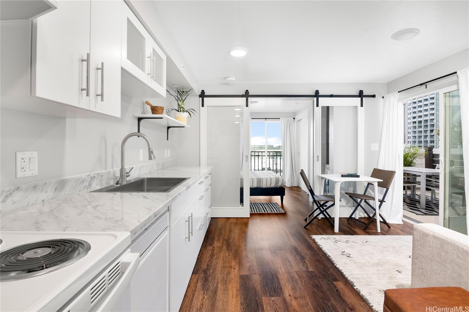 803 Waimanu Street Honolulu, HI 96813 - Photo 1 of 1 a kitchen with stainless steel appliances granite countertop a sink dishwasher and white cabinets with wooden floor