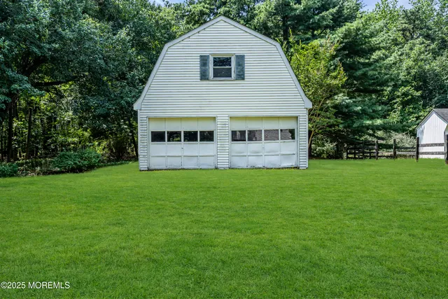 a view of a house with a big yard and large trees