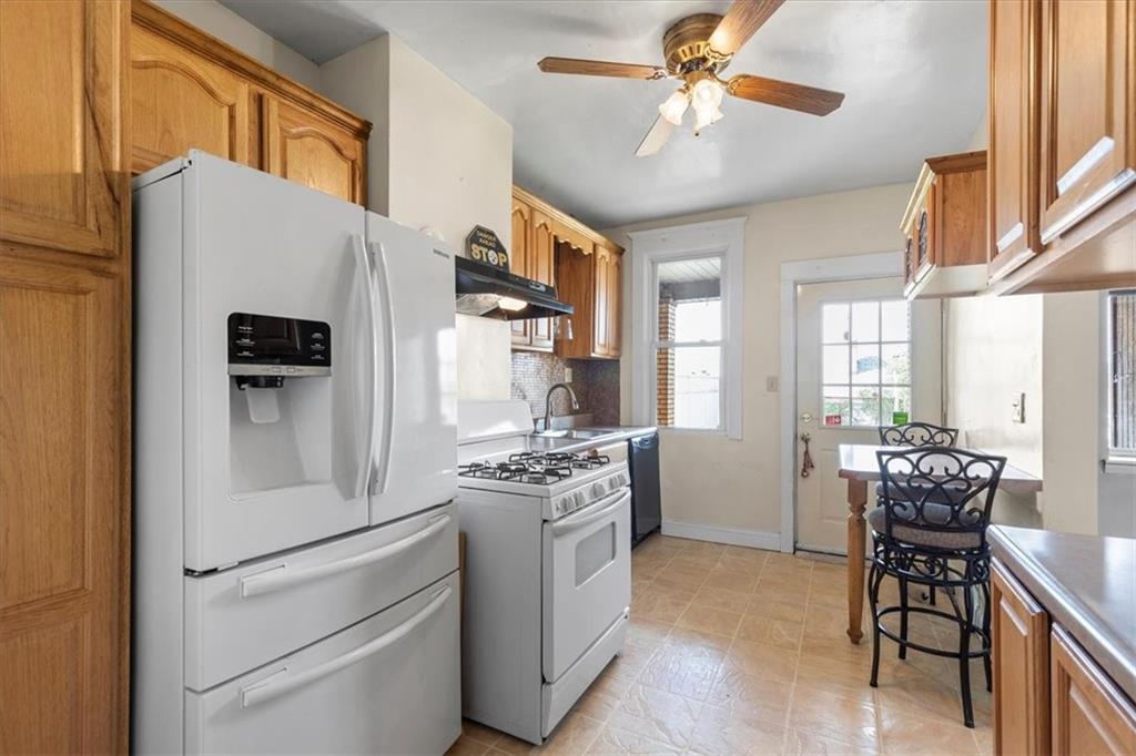 1622 Methyl Street Pittsburgh, PA 15216 - Photo 13 of 45 a kitchen with stainless steel appliances a refrigerator a stove a dining table and chairs with wooden floor