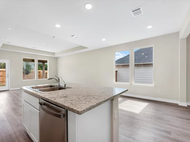 a kitchen that has a sink and a wooden floor
