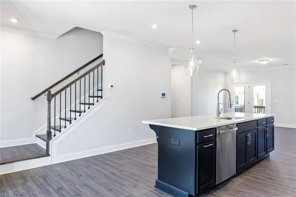 a kitchen with kitchen island a sink and wooden floor