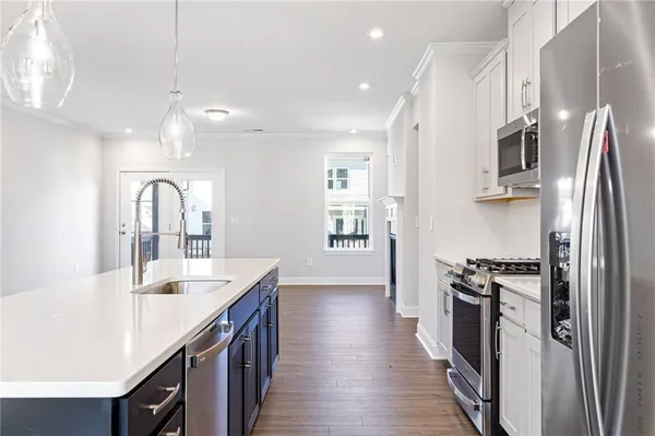 a kitchen with stainless steel appliances granite countertop a sink refrigerator and cabinets