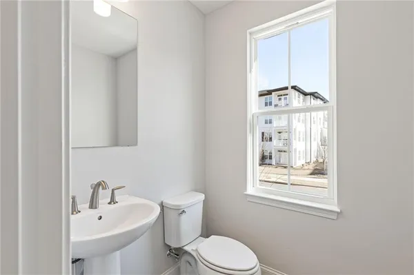 a bathroom with a sink a toilet and a window