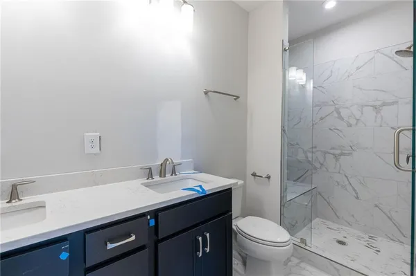 a bathroom with a granite countertop sink toilet and shower