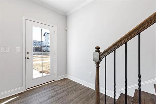 a view of an entryway with wooden floor and door