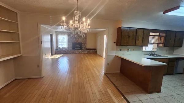 a large kitchen with stainless steel appliances granite countertop a oven and a wooden floors