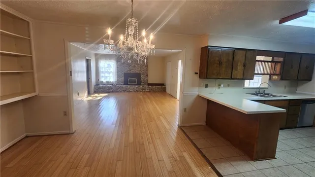 a large kitchen with stainless steel appliances granite countertop a oven and a wooden floors