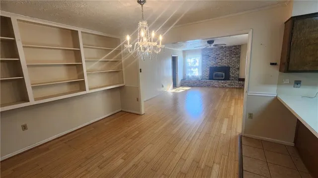 a view of a room with wooden floor and a kitchen space