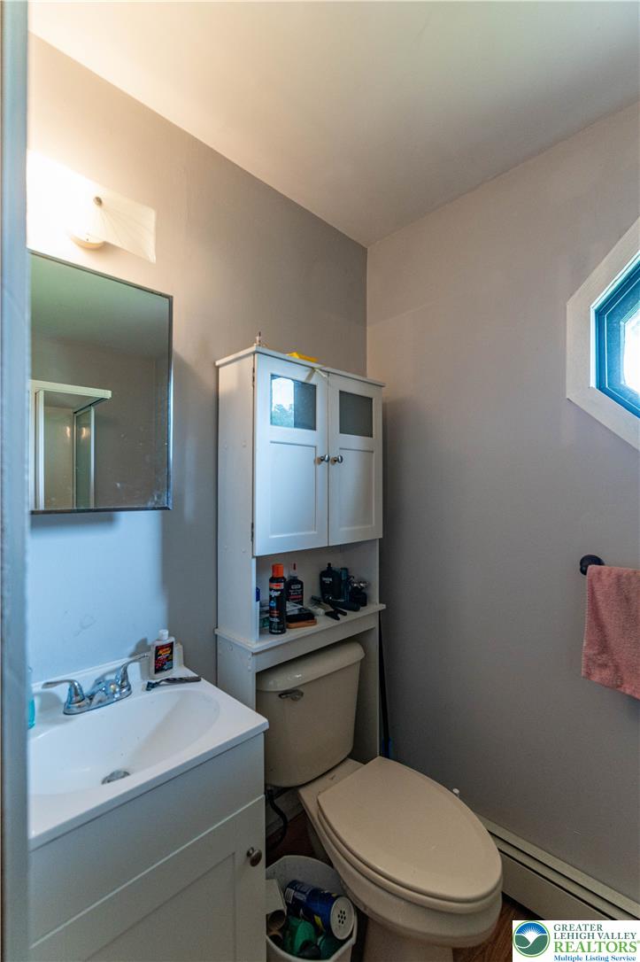 2485 Hieter Road Quakertown, PA 18951 - Photo 63 of 97 A compact bathroom featuring a sink vanity, toilet, and hexagonal window.
