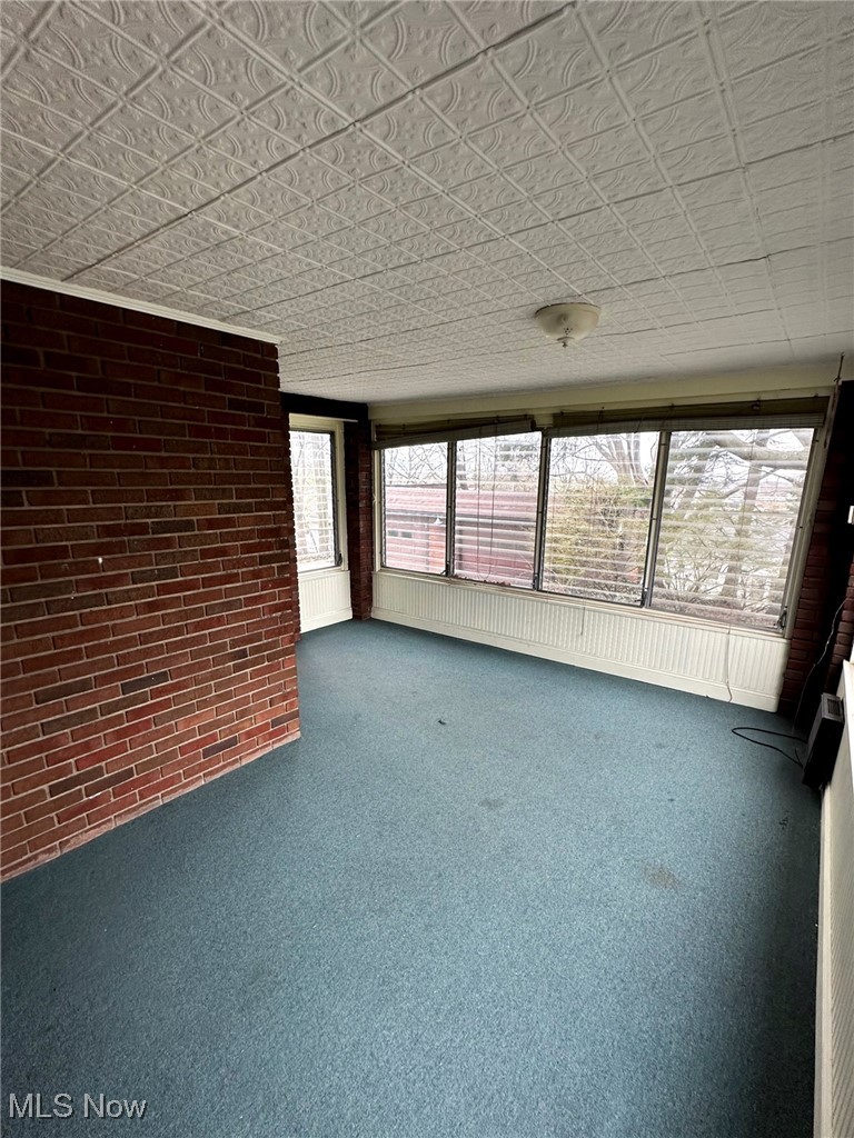 29213 Ridge Road Wickliffe, OH 44092 - Photo 47 of 47 Unfurnished sunroom featuring carpet floors and brick wall