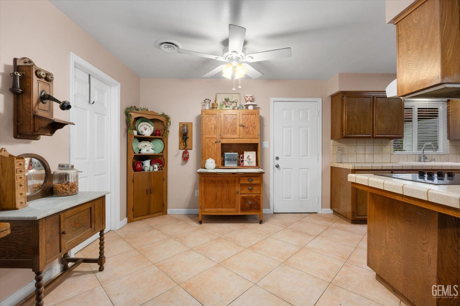 Undisclosed Address Bakersfield, CA 93309 - Photo 17 of 43 a kitchen with granite countertop a stove top oven a sink a dining table and chairs