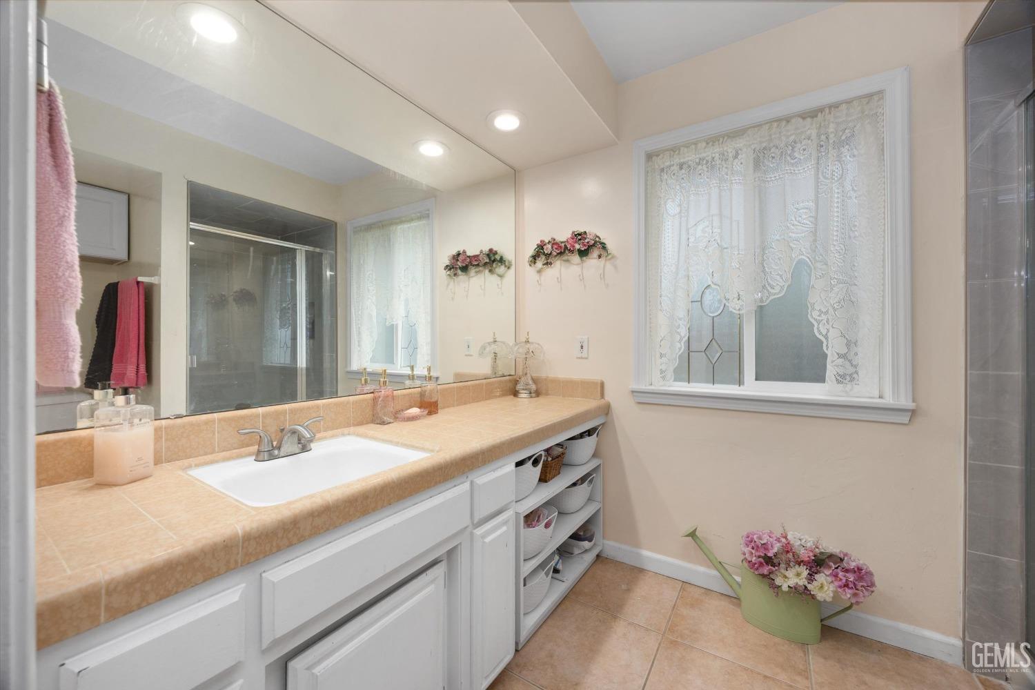Undisclosed Address Bakersfield, CA 93309 - Photo 24 of 43 a bathroom with a granite countertop sink and a mirror