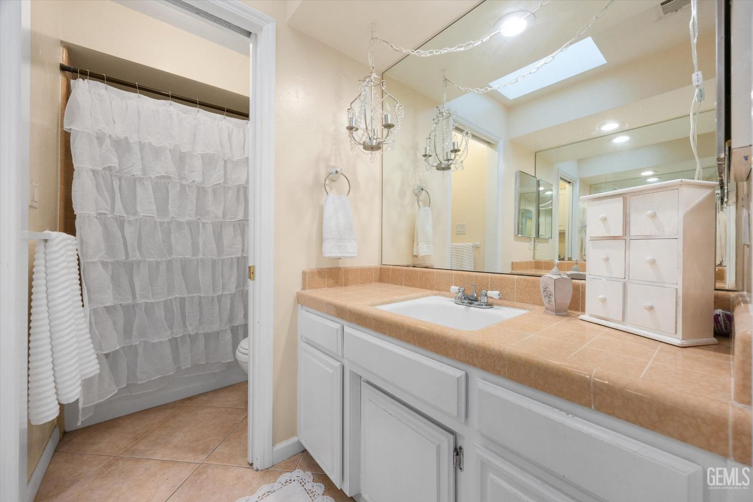 Undisclosed Address Bakersfield, CA 93309 - Photo 28 of 43 a bathroom with a granite countertop sink a mirror a shower and a bathtub