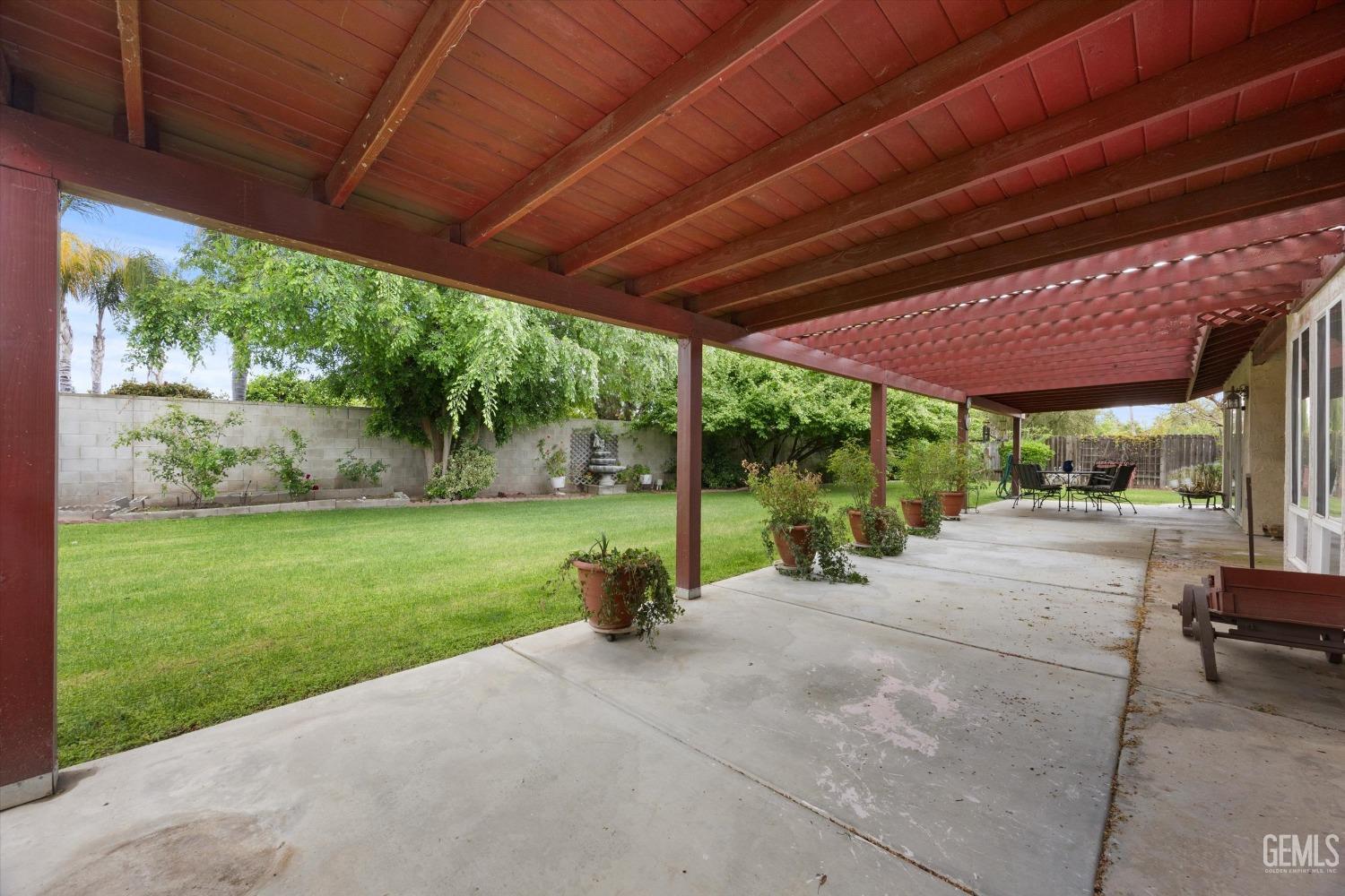 Undisclosed Address Bakersfield, CA 93309 - Photo 38 of 43 a view of a backyard with table and chairs under a large umbrella