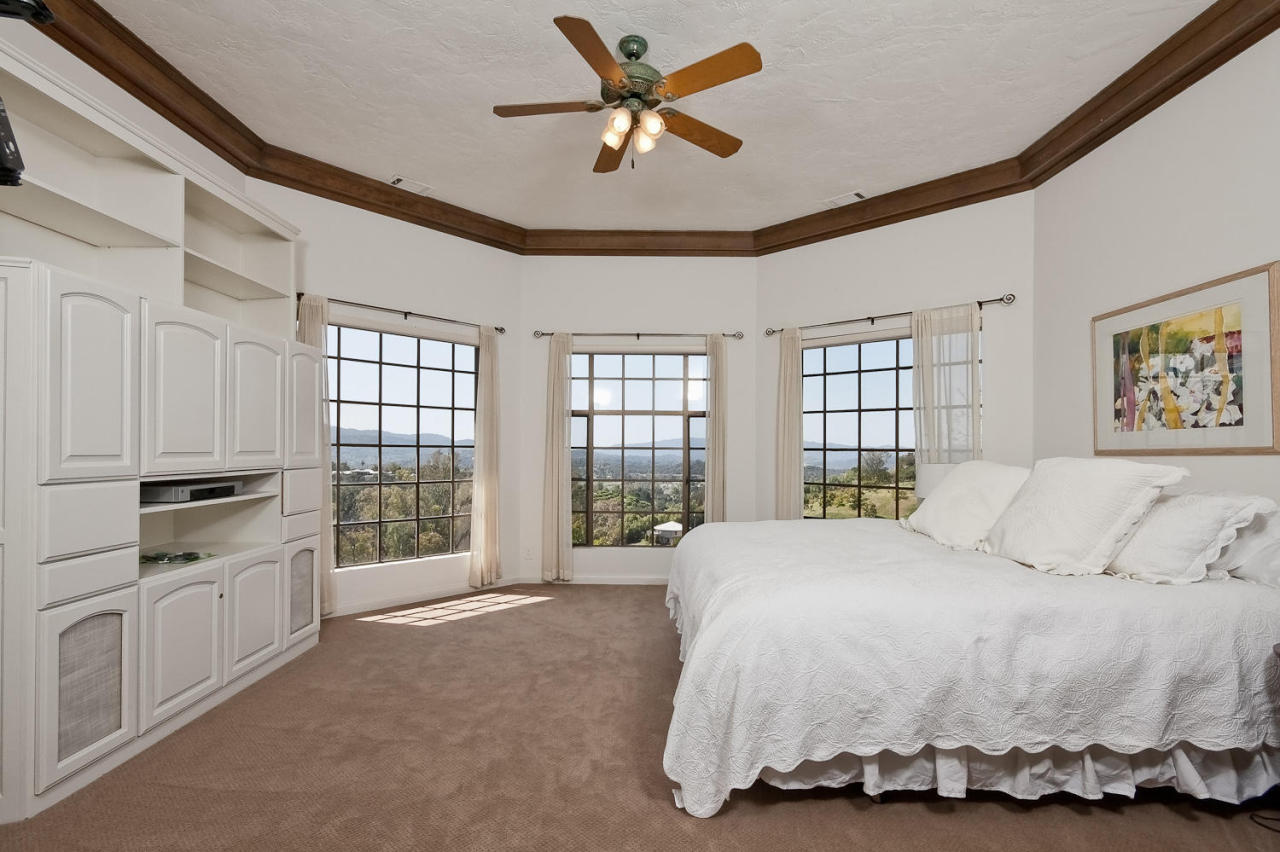 312 Fairview Road Ojai, CA 93023 - Photo 10 of 24 a spacious bedroom with a bed a dresser and a chandelier