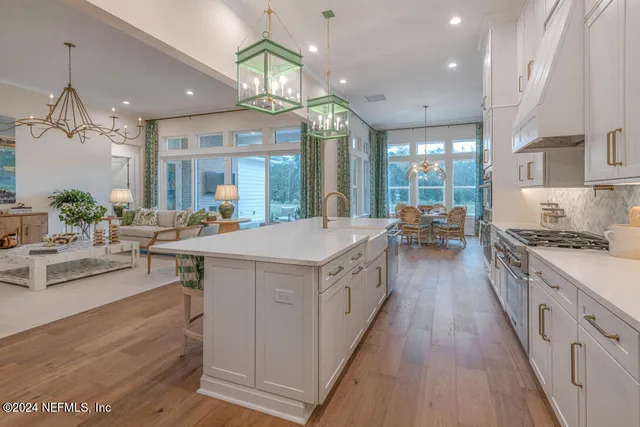 a kitchen with kitchen island granite countertop a stove and a view of living room