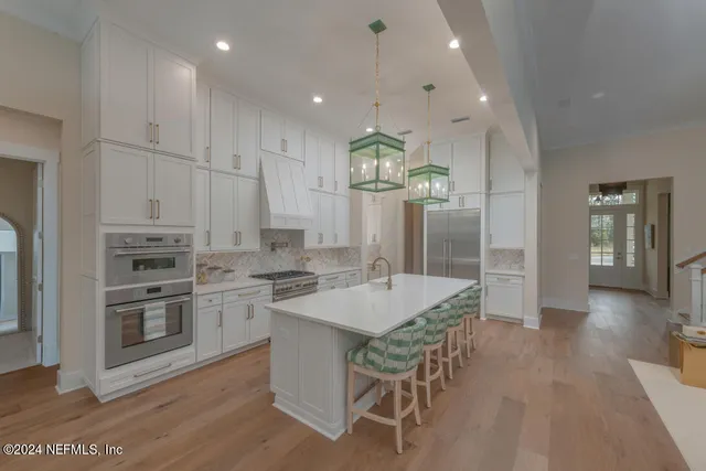 a kitchen with stainless steel appliances granite countertop a stove refrigerator and cabinets