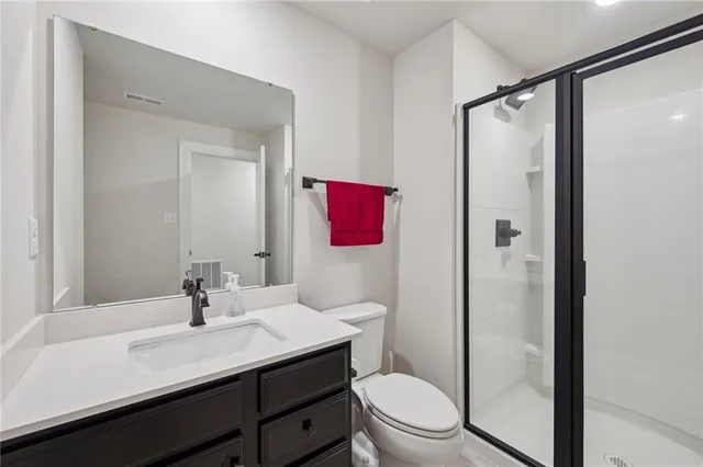 a bathroom with a sink a toilet a shower and a mirror