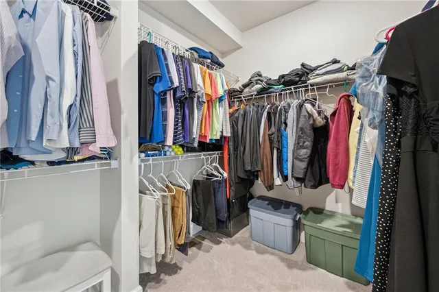 a view of walk in closet with clothes