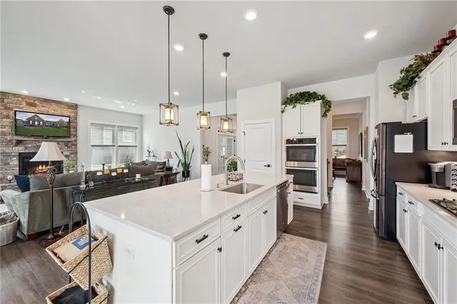 a large kitchen with kitchen island a large counter top appliances and cabinets