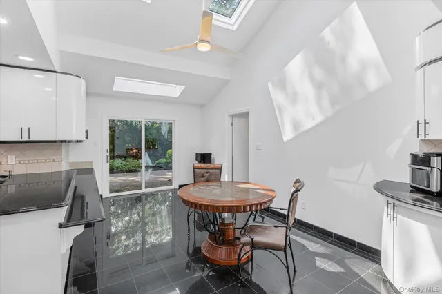 a kitchen with kitchen island granite countertop a sink a counter space appliances and cabinets