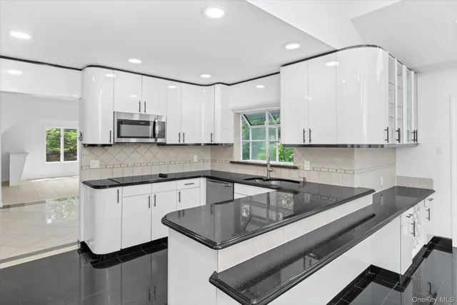a kitchen with stainless steel appliances granite countertop a sink and a stove